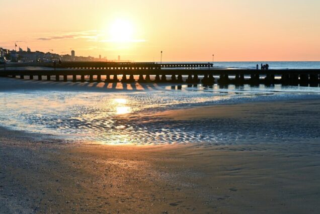 Beautiful sunset over Lido di Jesolo's sandy beach and pier in Italy.